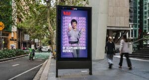 Digital City Ad Billboard Showing a Smiling Woman with a Purple Background and the Text 'layers and Layers of Scam and Fraud Defence'.