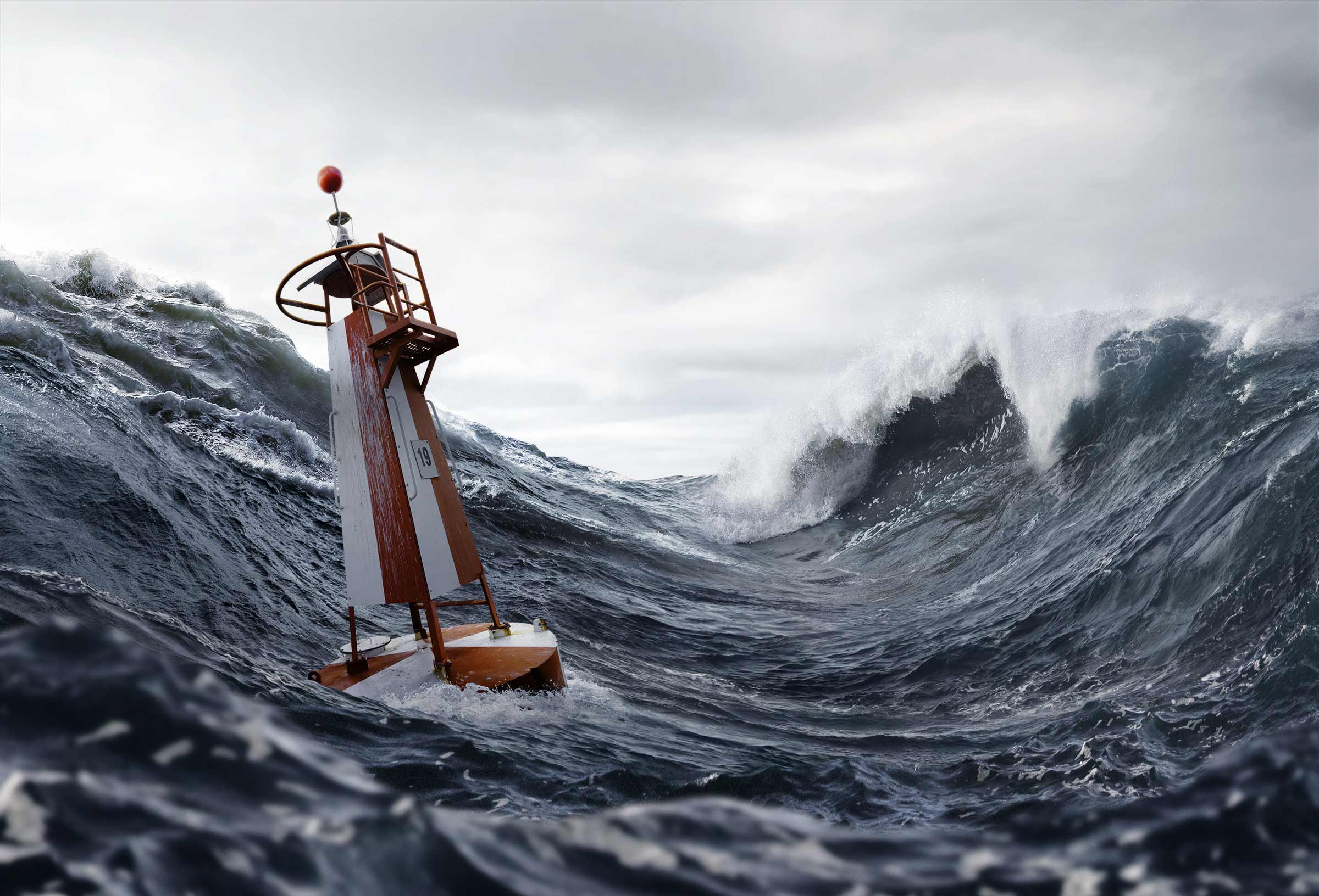 Lifeguard lookout tower tilting in rough seas with cresting dark waves and a gray cloudy sky; the orange-and-white structure leans against the surf.