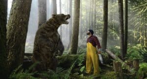 Man in Yellow Overalls and Plaid Shirt Holds a Large Fish, Facing a Roaring Bear in a Misty Forest.